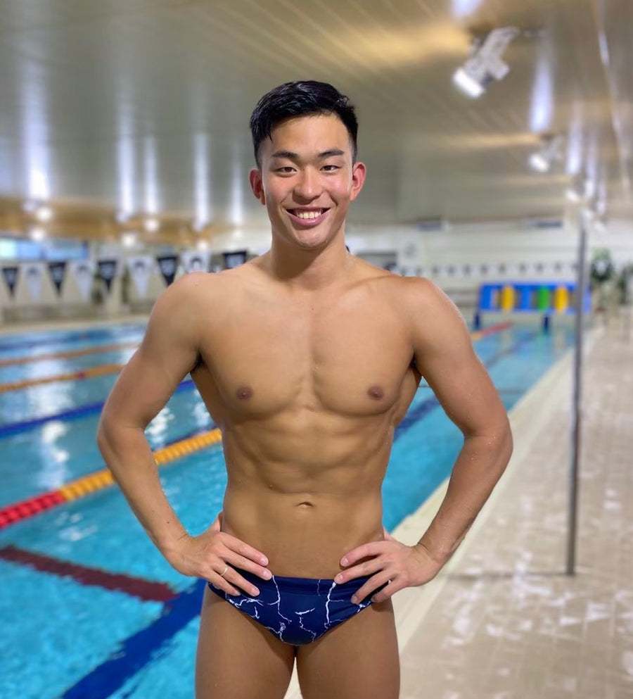 屋内プールで笑顔の男性選手